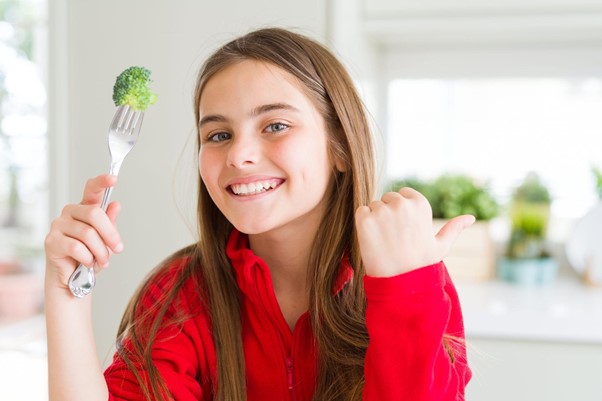 ブロッコリーを食べる女性の写真
