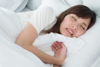 歯ぎしりをしながら寝る女性