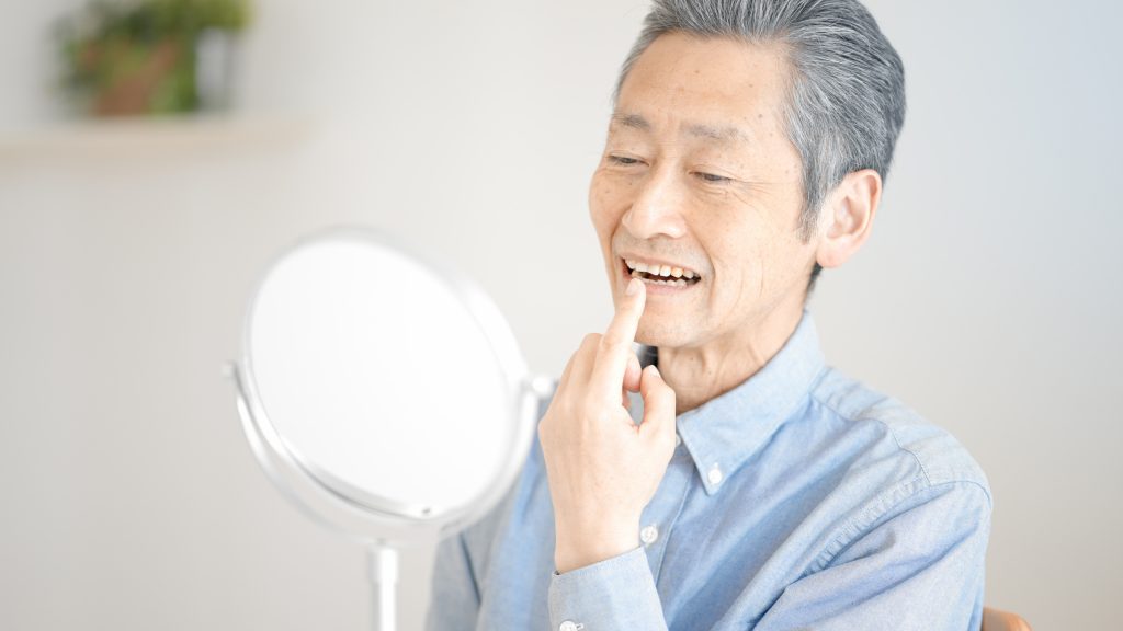 歯の状態を確認するシニア男性