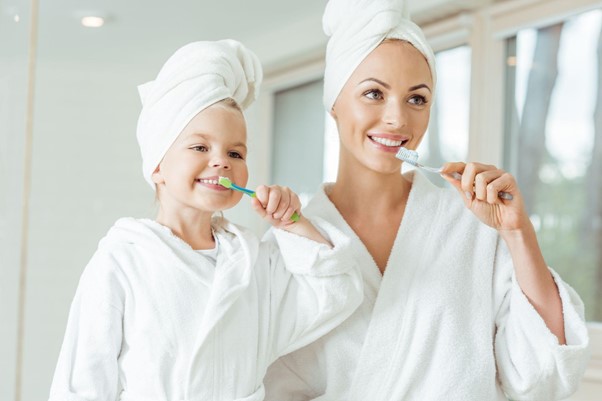 親子で歯磨きをしている写真